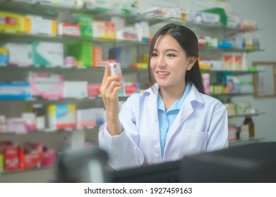 A Portrait Of Asian Woman Pharmacist Wearing Lab Coat In A Modern Pharmacy Drugstore.