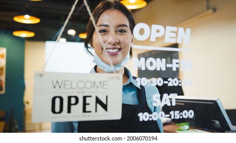 Portrait Of Asian Woman Restaurant Or Coffee Shop Owner Smile, Hanging Open Sign Post. Small Business Entrepreneur, Business Reopen After Covid-19 Coronavirus Pandemic, Covid Relief Lifestyle Concept