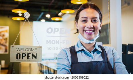 Portrait Of Asian Woman Restaurant Or Coffee Shop Owner Smile, Hanging Open Sign Post. Small Business Entrepreneur, Business Reopen After Covid-19 Coronavirus Pandemic, Covid Relief Lifestyle Concept