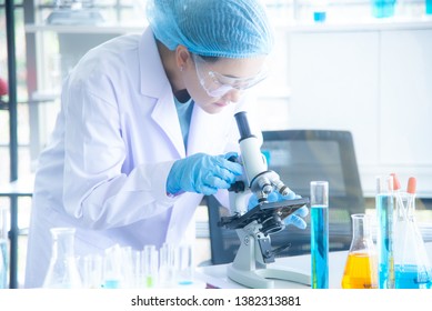 Portrait Asian Woman Scientist, Researcher, Technician, Or Student Conducted Research Or Experiment By Using Microscope Which Is Scientific Equipment In Medical, Chemistry Or  Biology Laboratory