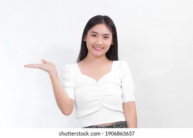 Portrait Asian woman is smiling and shows her hands to present something on the white background.