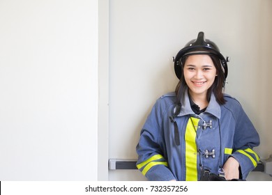 The Portrait Of Asian Woman Smiling And Wearing Fire Fighter Suit.