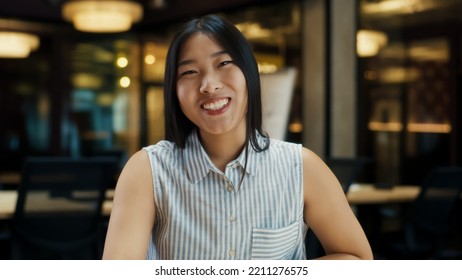 Portrait Of Asian Woman Talking Online With Client, Having Video Call, Working In Modern Office Of Marketing Company, Looking At Camera. Online Business Meeting. Computer Screen View. Webcam View