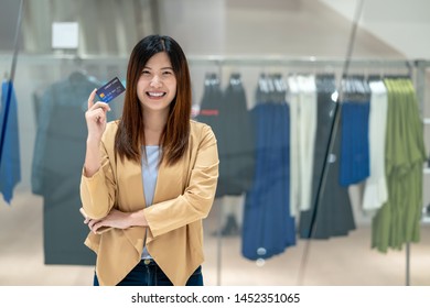 Portrait Asian woman using credit card with smart mobile phone for online shopping in department store over the clothes shop store background, technology money wallet and online payment concept - Shutterstock ID 1452351065