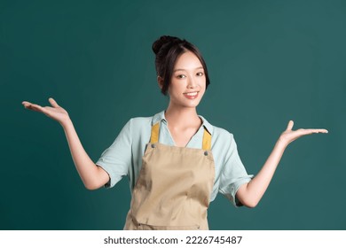 portrait of Asian woman wearing apron on green background - Powered by Shutterstock