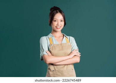 portrait of Asian woman wearing apron on green background - Powered by Shutterstock