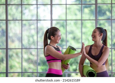 Portrait Of Asian Woman Wearing Sportswear Holding A Yoga Or Fitness Mat, Hi Five And Smile.