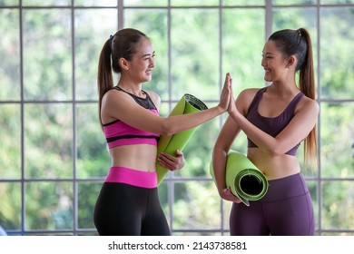 Portrait Of Asian Woman Wearing Sportswear Holding A Yoga Or Fitness Mat, Hi Five And Smile.