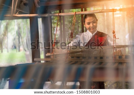 portrait Asian woman weaving silk sari on loom.  female works on cotton or silk weaving with traditional hand weaving loom. Asian traditional culture. concept of life, people and Small business