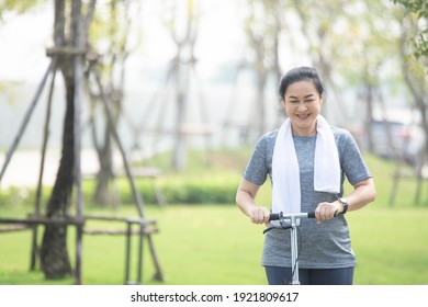 Portrait Asian Women Middle Aged Playing Scooter In City Park In Concept Healthy Strong Insurance Retire Financial Freedom