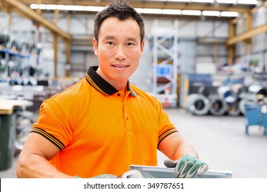 Portrait Of Asian Worker In Production Plant Working On The Factory Floor