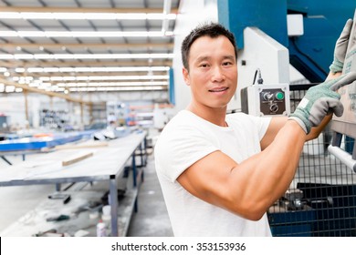 Portrait Of Asian Worker In Production Plant Working On The Factory Floor