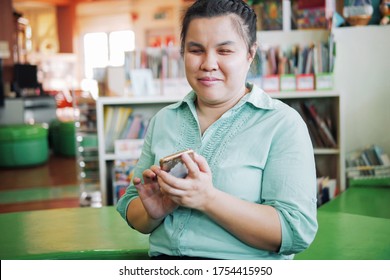 Portrait of Asian young blind person woman using smart phone with voice accessibility for persons with disabilities in creative workplace