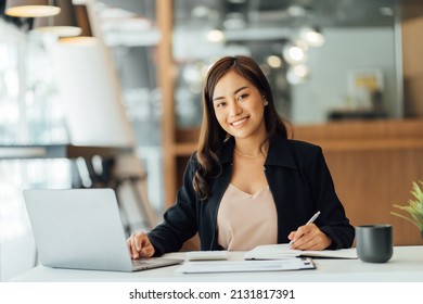 Portrait of an Asian young business Female working on a laptop computer in her workstation.Business people employee freelance online report marketing e-commerce telemarketing concept. - Shutterstock ID 2131817391