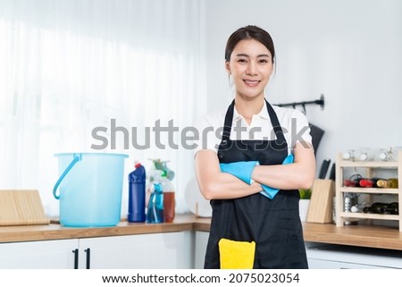 Portrait of Asian young cleaning service woman worker working in house. Beautiful girl housewife housekeeper cleaner crossing arm and smile, looking at camera after doing housework or chores at home.