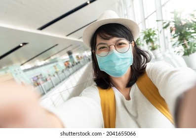 Portrait of Asian Young Female tourist wearing protective face mask taking selfie.