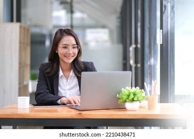 Portrait Of Asian Young Female Working On Laptop At Office