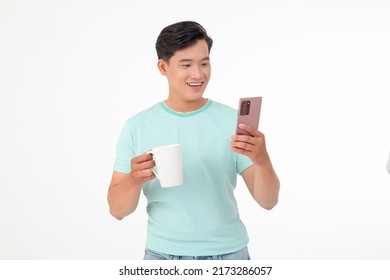 Portrait of Asian young handsome and cheerful man, isolated on white background. Concept of drinking coffee or tea, holding mug, checking smart phone - Powered by Shutterstock