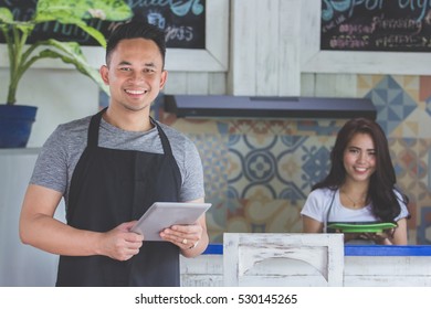 Portrait Of Asian Young Male Cafe Owner With Tablet