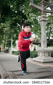 Portrait asian young man doing jogging reducing weight in the park with jacket clothes
