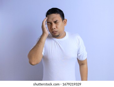 Portrait of Asian young man isolated on white background suffering from severe headache. Feeling sick - Shutterstock ID 1679219329