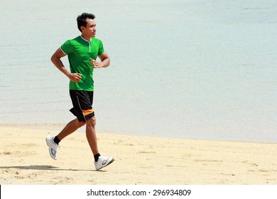 A Portrait Of A Asian Young Man Running On Beach, Sport Concept