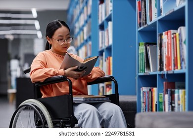 Portrait of Asian young woman with disability reading book in library, student inclusivity concept - Powered by Shutterstock