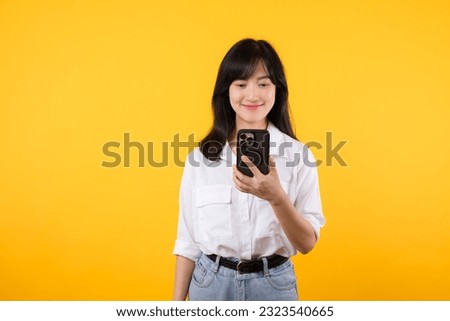 Portrait asian young woman happy smile wearing white shirt and denim jean plants using a smartphone isolated on yellow background. app smartphone concept.
