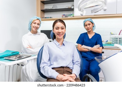 Portrait Of Asian Young Woman Patient And Dentist At Health Care Clinic. Attractive Girl Sitting On Dental Chair After Getting Dental Treatment From Doctor During Appointment Then Looking At Camera.