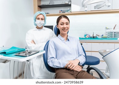 Portrait of Asian young woman patient and dentist at health care clinic. Attractive girl sitting on dental chair after getting dental treatment from doctor during appointment then looking at camera. - Powered by Shutterstock