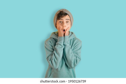 Portrait of astonished boy. Teenager impressed with incredible novelty. Child in casual style outfit isolated on blue background. Back to school web banner.