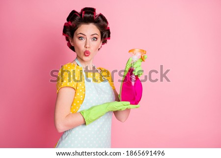 Portrait of astonished girl hold bottle sprayer wear yellow dotted t-shirt isolated over pastel color background