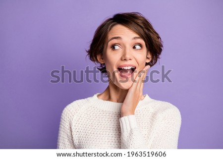Portrait of astonished person arm on cheek look empty space open mouth wear pullover isolated on purple color background