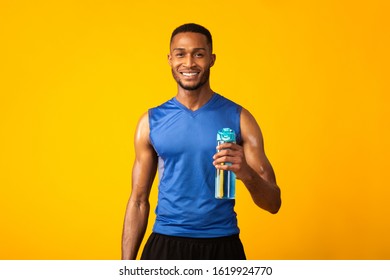 Portrait Of Athletic Black Man Holding Bottle Of Refreshing Water, Resting After Workout, Thirsty Male With A Drink - Powered by Shutterstock