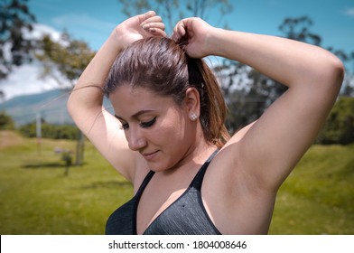 Portrait Of An Athletic Latina Woman Holding Her Hair Back Before Running