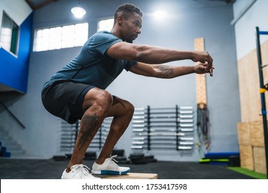 Portrait of an athletic man doing box jump exercise. Crossfit, sport and healthy lifestyle concept.