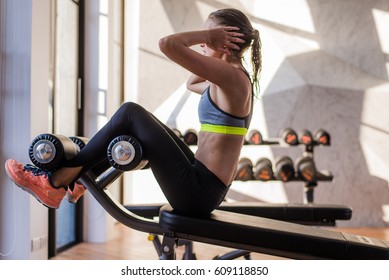 Portrait Of An Athletic Woman Doing Exercising Abdominals Work-out Lying In Gym At Luxury Hotel At Summer