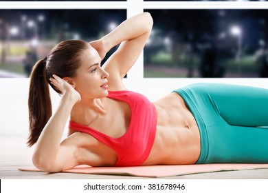 Portrait of athletic young woman workout at fitness class in evening