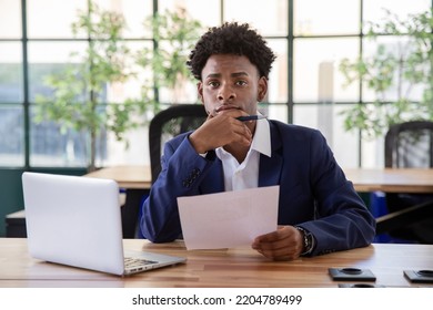 Portrait Of Attentive Male Office Worker. Serious Businessman Looking At Camera, Holding Hand On Chin And Reading Document. Paperwork, Office Work Concept.