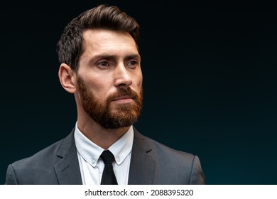 Portrait Of Attentive Self Confident Bearded Man Looking Away With Serious Expression, Unsmiling Determined Business Man. Indoor Studio Shot Isolated On Black Background 