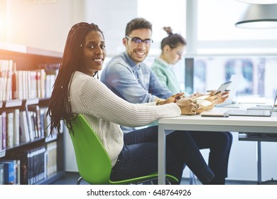 Portrait Of Attractive Afro American Model Working Together With Colleagues In Modern Office Preparing Report, Beautiful Black Female Student Sitting In University Library Doing Homework Task