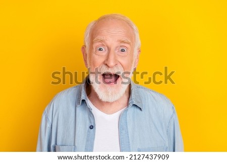 Portrait of attractive amazed cheerful grey-haired man incredible news reaction isolated over bright yellow color background