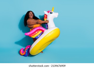 Portrait of attractive amazed cheery thick woman riding fairy horse fooling isolated over bright blue color background.