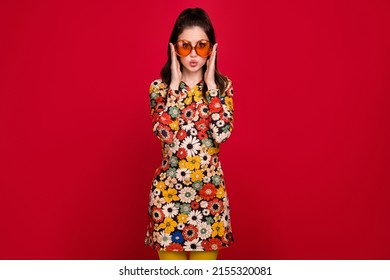 Portrait of attractive amazed funny cheerful girly girl touching specs pout lips isolated over bright red color background