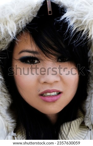 Portrait Of Attractive Asian American Woman Wearing A Winter Jacket Hood With Fur