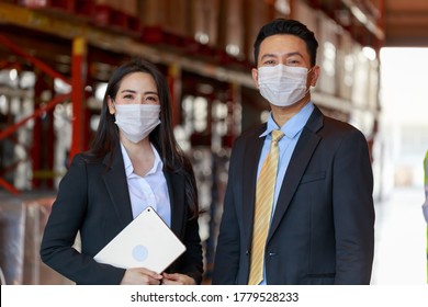 Portrait Of Attractive Asian Business Man And Investor Woman Wearing Protective Face Mask In Warehouse, New Normal After Covid-19 Corona Virus Pandemic.