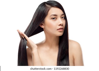 Portrait Of Attractive Asian Model With Strong And Healthy Hair Looking At Camera Isolated On White