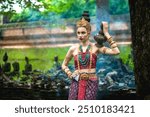 Portrait attractive Asian woman in fashionable Dvaravadi costume holding clay pottery on shoulder in ancient temple