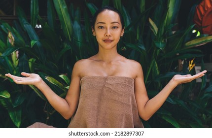 Portrait of attractive Asian woman in towel raising hands and looking at camera while waiting for spa procedure at nature, charming Korean female posing as beauty model during weekend leisure - Shutterstock ID 2182897307