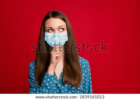 Portrait of attractive brown-haired girl thinking touching chin copy space wear mask isolated bright red color background